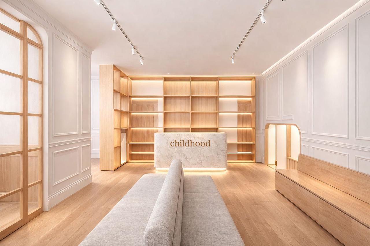Recepción de Childhood Centro Médico en Arcos Bosques, con madera clara y luz cálida